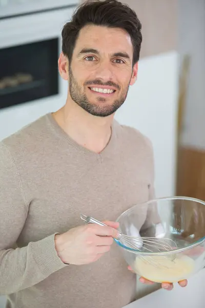 stock image calm adult person standing whisking eggs in the bowl