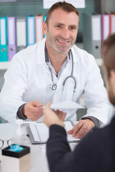 Stock image patient and happy doctor taking notes