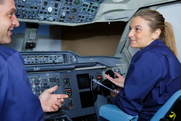 stock image woman apprentice questioning man in cockpit of aircraft