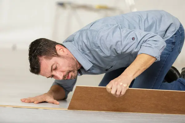 stock image a man during flooring installation