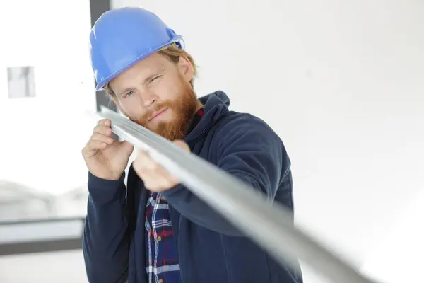 Stock image young man checks metal profiles