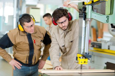 male operator using a milling machine for cutting wood clipart