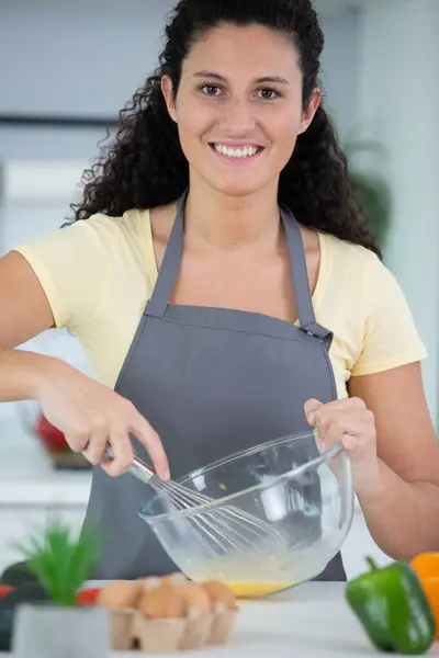 stock image young lady at home whisking eggs