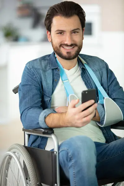 stock image injured man in wheelchair making telephone call