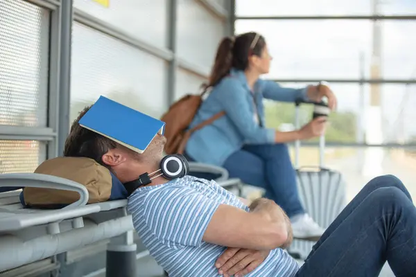 Stock image tired caucasian couple sitting at train station