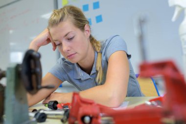 a woman studying mechanical parts clipart