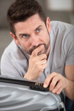 man trying to remember the code for his suitcase lock clipart