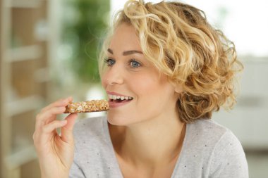 beautiful woman eating a cereal bar clipart