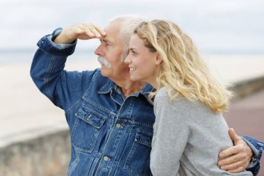 a senior man with adult daughter at sea clipart