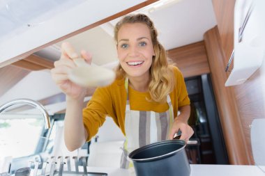 happy woman cooking in camper clipart