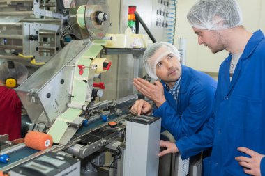 man and woman wearing hair nets in factory clipart