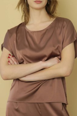 Stüdyo fotoğraflarının serisi. Kahverengi ipek takım elbiseli genç bir kadın model.