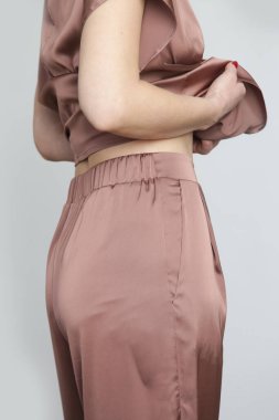 Stüdyo fotoğraflarının serisi. Kahverengi ipek takım elbiseli genç bir kadın model.