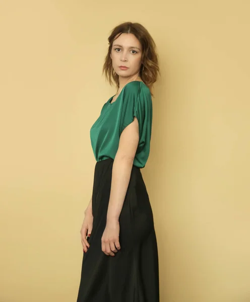 セリエのスタジオ写真の若い女性モデル身に着けている緑のブラウスと黒のスカート — ストック写真