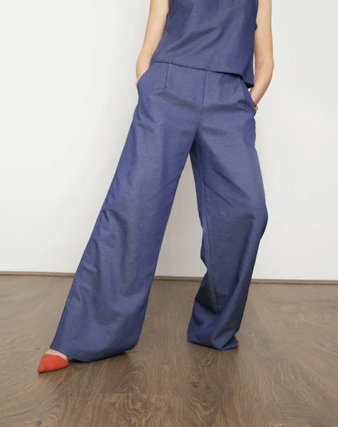 Woman in blue denim blouse and wide pants, studio shot.Denim on denim fashion trend.