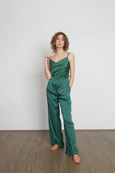 緑の絹のモノクロームの衣装 キャミソールトップとパンツを身に着けている女性モデル クラシックでシンプルな夏のファッション スタジオショット — ストック写真