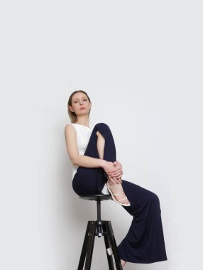 Stüdyo fotoğrafları, basit rahat kıyafetler, organik pamuk gömlek ve siyah pantolon giyen genç kadın modeller.