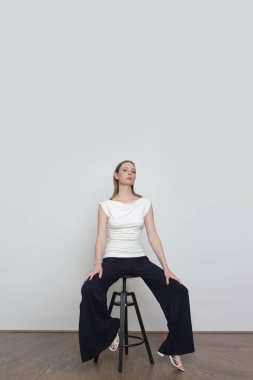 Stüdyo fotoğrafları, basit rahat kıyafetler, organik pamuk gömlek ve siyah pantolon giyen genç kadın modeller.