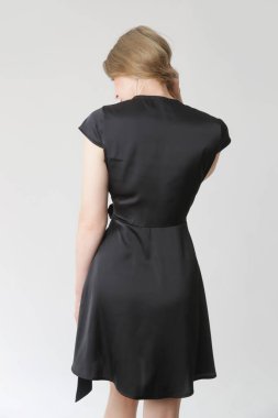 Stüdyo fotoğraflarının serisi. Siyah ipek saten elbise giymiş genç bir kadın model..