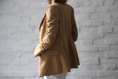 Studio portrait of young female model in beige tailored blazer