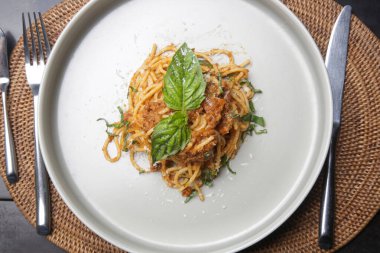 Portion of homemade spaghetti bolognese served in ceramic plate.