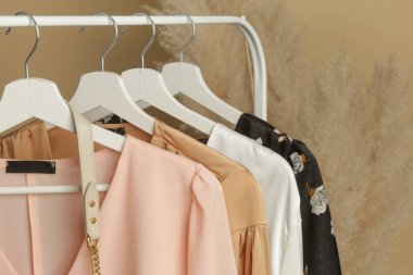 Kadın kıyafetleri. Moda atölyesindeki şık ve şık elbiseli elbise askılığı resmini kapat. Minimalist moda blogu kavramı.