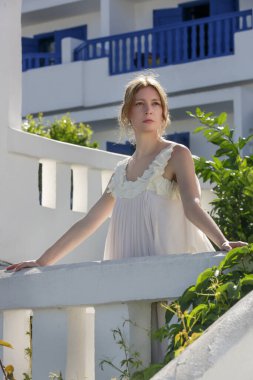 Portrait of the bride in long white wedding dress in the tourist resort, destination wedding concept. Island relaxed boho style bridal fashion.