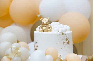 Creative gender neutral baby shower or birthday decoration in the garden. Bohemian style outdoor event set up with balloons. White cream peach caramel balloon arch kit. Sweet table for a party