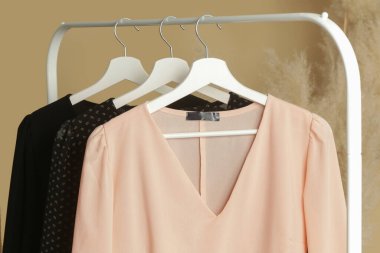 Kadın kıyafetleri. Moda atölyesinde şık ve şık giysilerle elbise askısı. Kaliteli, zamansız moda eserleri.