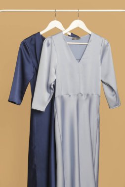Women's Clothes. Clothes rack with stylish and elegant blue silk dresses in fashion atelier. Good quality timeless fashion pieces.