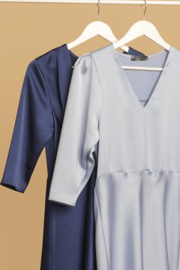 Women's Clothes. Clothes rack with stylish and elegant blue silk dresses in fashion atelier. Good quality timeless fashion pieces.