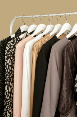 Kadın kıyafetleri. Moda atölyesindeki şık ve şık elbiseli elbise askılığı resmini kapat. Minimalist moda blogu kavramı.