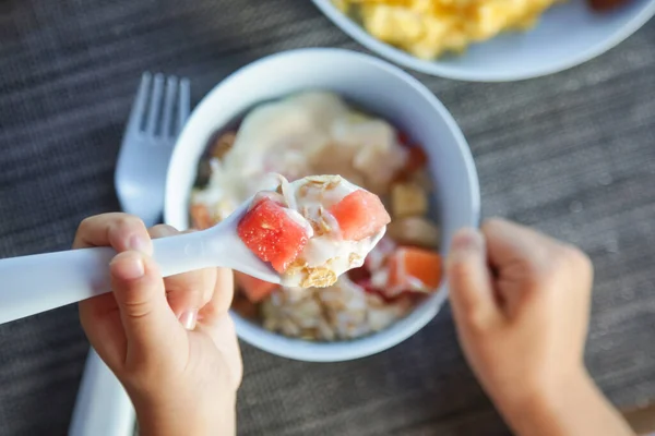 小女孩用酸奶吃意大利面 用白色塑料勺子吃水果 — 图库照片