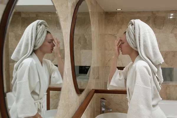 シャワー後の鏡の前でアンチエイジングフェイスマッサージをする女 自宅で美容スキンケアコンセプト — ストック写真