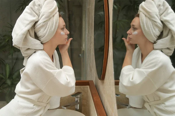 Frau Trägt Gesichtscreme Auf Ihre Haut Vor Dem Spiegel Befeuchten — Stockfoto