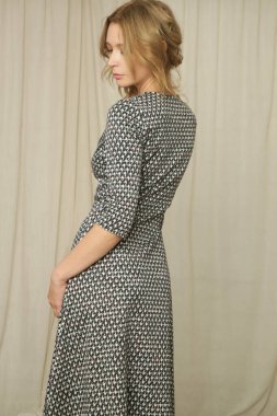 Stüdyo fotoğraflarının serisi. Siyah beyaz, zarif bir elbise giymiş genç bir kadın manken. 