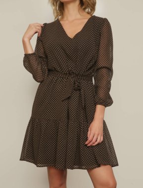 Boho tarzında kahverengi desenli elbiseli genç bir kadının stüdyo fotoğrafları.