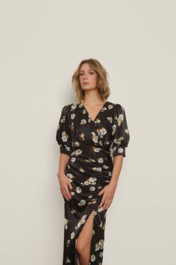 Stüdyo fotoğraflarının serisi. Koyu renkli ipek ipek Midi elbisesi içinde genç bir kadın manken..