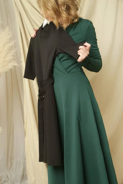 緑と黒のドレスの間で選択ファッションアトリエの若い女性 — ストック写真