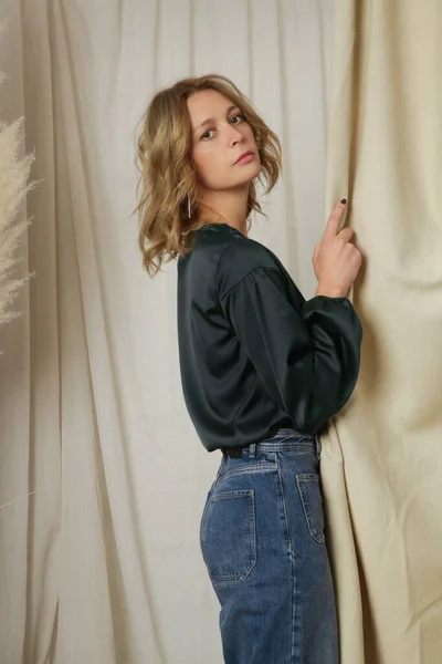 黒絹のブラウスとリラックスしたジーンズの若い女性モデルのスタジオ写真 — ストック写真
