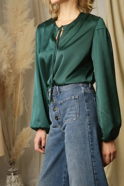 セリエのスタジオ写真の若い女性モデルで松緑の絹のブラウスとリラックスしたジーンズ — ストック写真