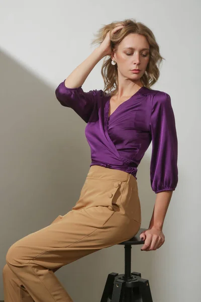 女模穿着紫罗兰色绸缎围裙和米黄色高耸长裤的摄影棚照片系列 — 图库照片
