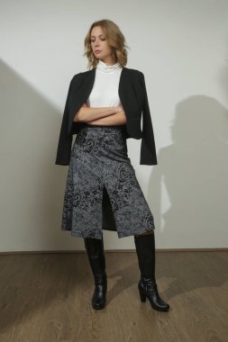Yapışkan ceket giyen ve yün etek, siyah beyaz elbise giyen genç bir modelin seri fotoğrafları.