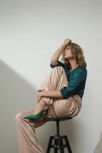 穿着丝绸缎子经典服装 翡翠绿色紧身衣和宽腿米色长裤的年轻女模特的摄影棚照片系列 — 图库照片