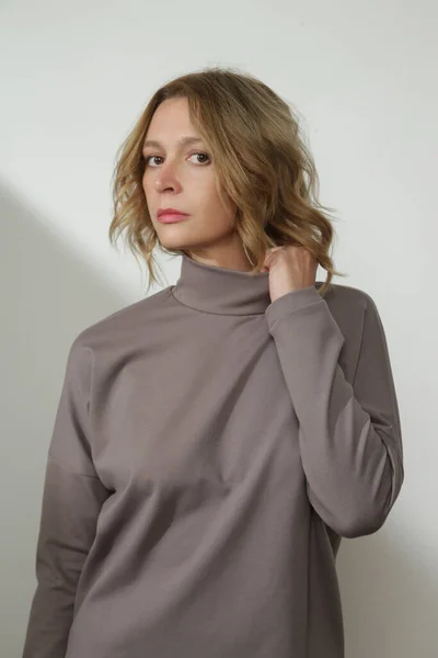 穿着经典灰棕色基本套头衫的年轻女模特的摄影棚照片系列 — 图库照片