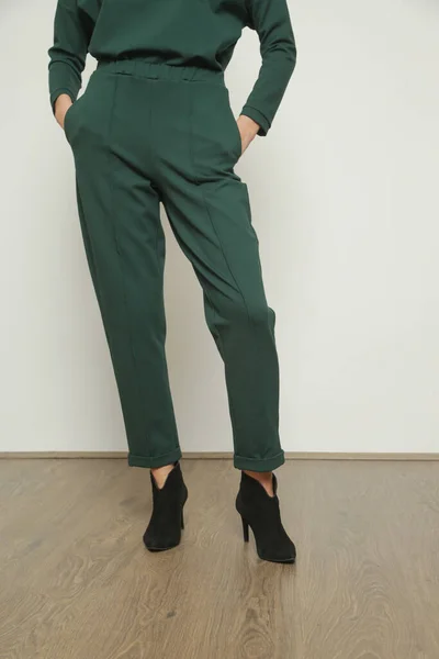 年轻女模穿着舒适的绿色高腰夹缝香烟长裤和侧边口袋的摄影棚照片系列 — 图库照片