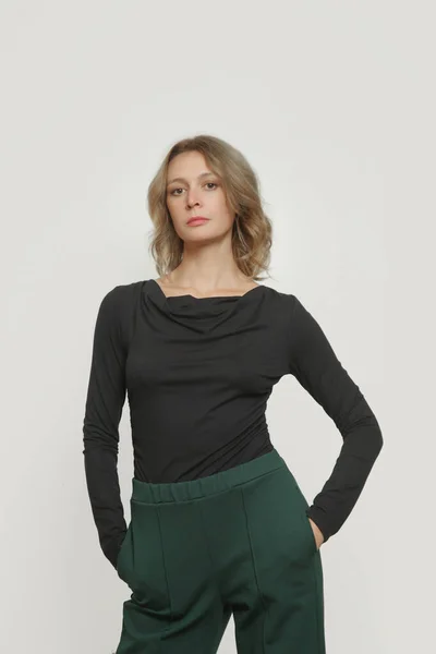 快適な基本的な服を着て若い女性モデルのスタジオ写真のセリエ ビスコースフィットシャツや基本的なタバコのズボン — ストック写真