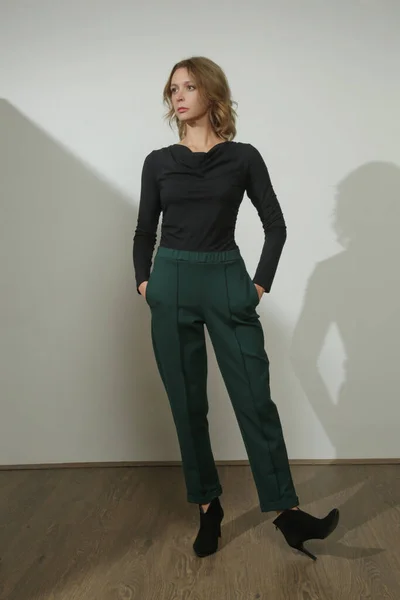 快適な基本的な服を着て若い女性モデルのスタジオ写真のセリエ ビスコースフィットシャツや基本的なタバコのズボン — ストック写真