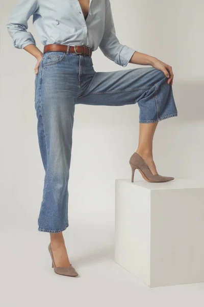 ワイドレッグジーンズを着用し ハイヒールをスエード女性モデルのスタジオショット 古典的な時代を超えたファッションアイテム — ストック写真