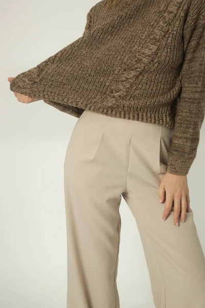 스웨터를 배경에 베이지 바지를 여성의 — 스톡 사진